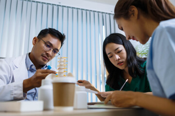 A doctor and a nurse are examining a model of a heart. The doctor is explaining the anatomy of the heart to the nurse
