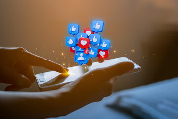 A woman's hands holding a smartphone with holographic social media icons for likes and hearts, symbolizing engagement and online communication in the digital marketing era.