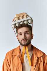 Man challenges plastic waste with creative egg carton headpiece in modern art setting
