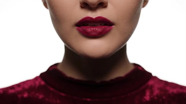 Close up of a womans lips with dark red lipstick.