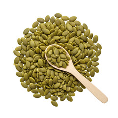 Pile of green pumpkin seeds with a wooden spoon pepitas
