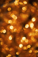 Golden bokeh lights creating festive abstract background with warm glowing circles evoking...