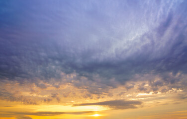 Obraz premium Beautiful colorful evening or morning fluffy clouds in sky. Blue and yellow cloudscape at sunset or sunrise. Nature background.