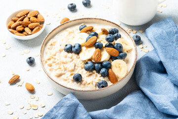Oatmeal porridge with bananas, nuts and blueberries.