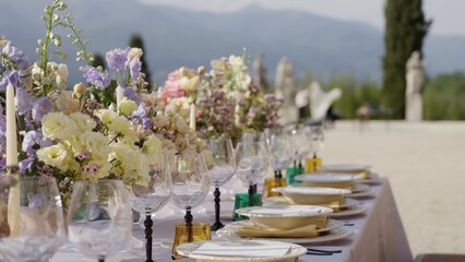 Elegant table setting with flowers for an outdoor wedding reception. Action