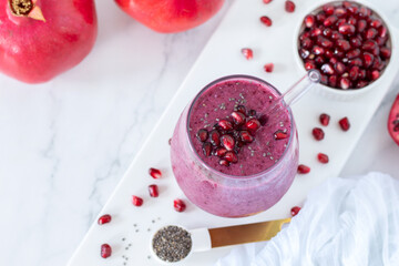 Pomegranate smoothie with chia seeds on white marble kitchen table. Top view. Healthy blended drink for breakfast.