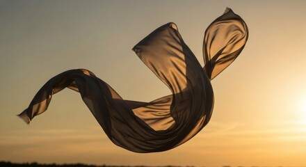 Light, translucent fabric billows in the golden light of sunset