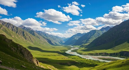 Obraz premium Panoramic valley view, verdant meadows, winding river, rugged mountains, bright sunlight, fluffy clouds