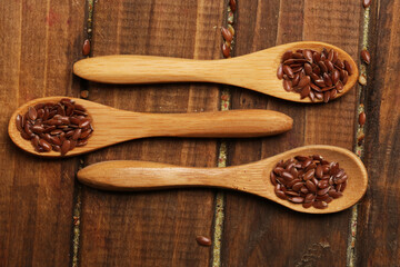 Wooden spoons with flax seeds, top view