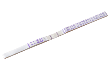 Positive pregnancy test and notebook with pen