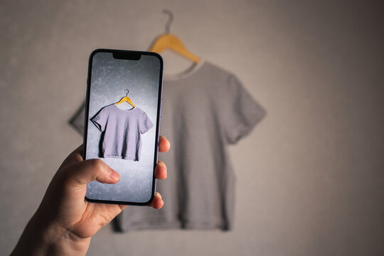 Woman photographs her old outfits for resale. Online resale platforms. Save planet and ecology concept.