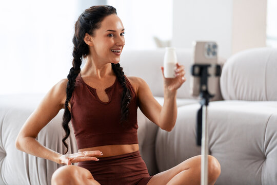 Woman health influencer creating content holding yogurt drink - Powered by Adobe