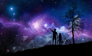 Fototapeta premium Silhouette of a father and daughter stargazing together with a bicycle under a vibrant purple night sky filled with stars, galaxies, and cosmic clouds. A leafless tree completes the scene