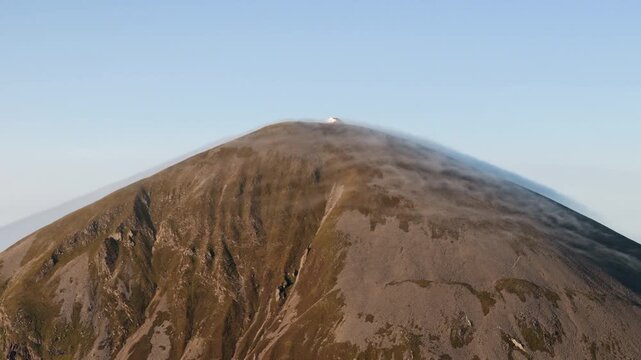 Amazing 4K aerial video of flying above and around Most Famous mountain in Ireland - Croagh Patrick in windy weather, with moving fog and clouds with breathtaking views around, Westport, Ireland