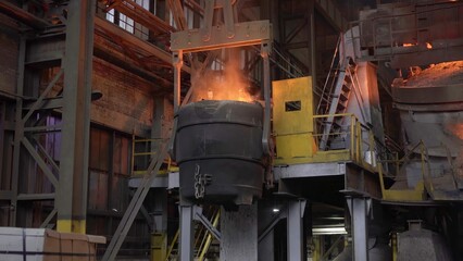 Industrial crane lifting molten metal ladle in steel mill. Stock clip © mediawhalelicensing 