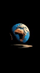 A stylized Earth globe, predominantly blue and tan, floats against a stark black background, casting a subtle shadow below.  Its continents are visibly textured