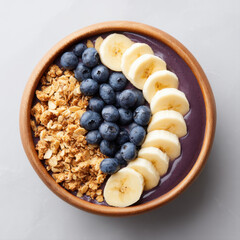 Delicious acai bowl topped with fresh blueberries, sliced banana, and crunchy granola in wooden bowl, perfect for healthy breakfast