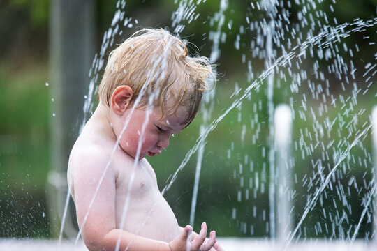 Child standing in spray of water from a sprinkler