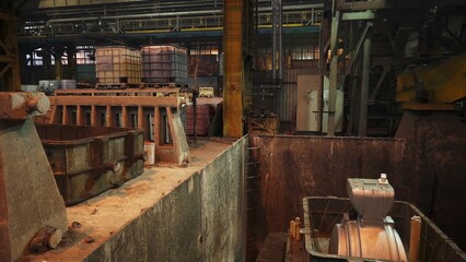 Industrial robotic arm pouring molten metal into mold in foundry. Stock clip