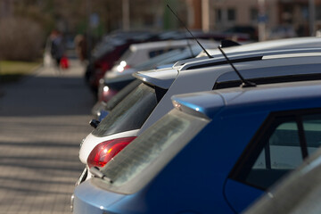 busy parking lot with cars, compact vehicle tail lights in city lot, shallow focus on cars in urban...