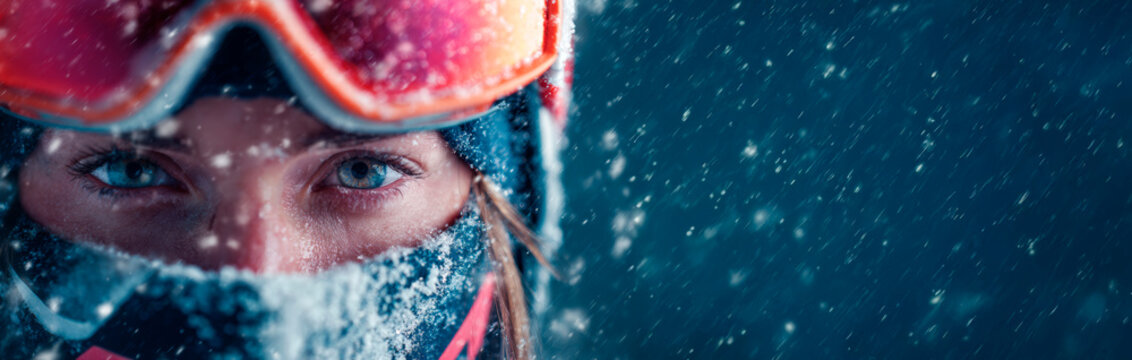Winter athlete wearing ski goggles in a snowstorm with copy space: Winter Olympics and extreme sports concept