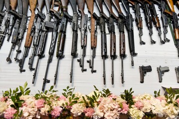 A display of surrendered weapons, including rifles others, laid out on a table