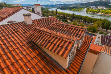 A high-angle view captures weathered terracotta rooftops overlooking a scenic river