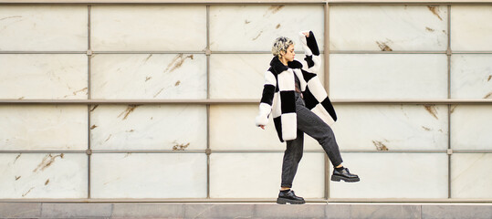 Young woman confidently walking wearing stylish checkerboard coat