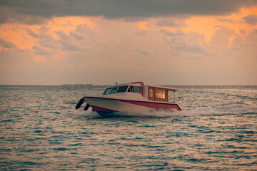 Tranquil sunset sea sky Maldives speedboat transfer taxi going fast back to luxury resort exotic...