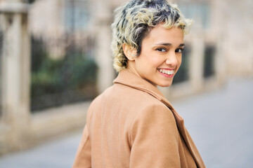 Woman smiling and looking over shoulder in city
