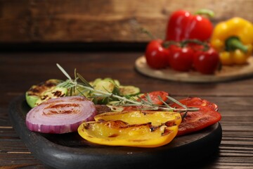 Vegetarian barbeque. Tasty grilled vegetables served on wooden table, closeup