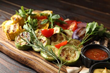 Vegetarian barbeque. Tasty grilled vegetables served on wooden table, closeup