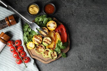 Vegetarian barbeque. Tasty grilled vegetables served on grey table, flat lay. Space for text