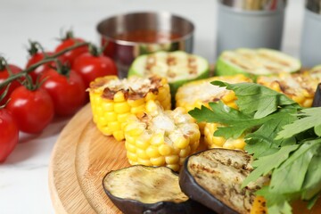 Vegetarian barbeque. Tasty grilled vegetables served on white table, closeup