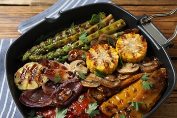 Delicious grilled vegetables, mushrooms and spices in pan on table, closeup
