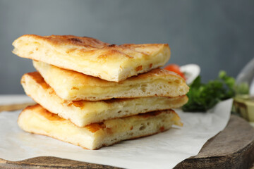 Pieces of delicious Megrelian khachapuri and products on table, closeup