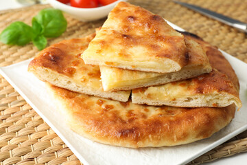 Pieces of delicious Megrelian khachapuri and products on table, closeup