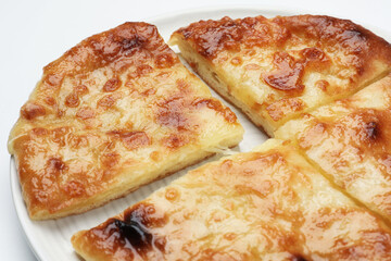Cut delicious Megrelian khachapuri on white background, closeup