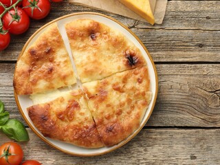 Delicious Megrelian khachapuri and products on wooden table, flat lay