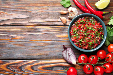 Tasty salsa sauce and ingredients on wooden table, flat lay. Space for text