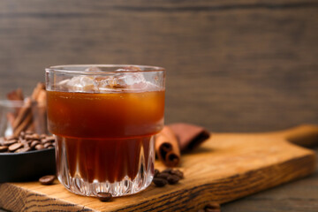 Tasty iced coffee and beans on wooden table, closeup. Space for text