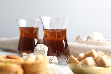 Traditional Turkish tea, brown sugar and sweets on table, closeup