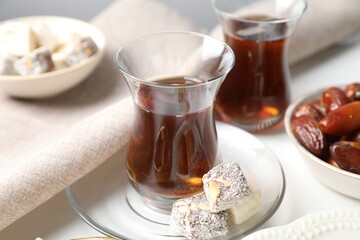 Traditional Turkish tea served with sweets on white table, closeup