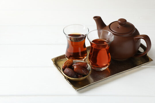 Traditional Turkish tea and dates on white wooden table. Space for text