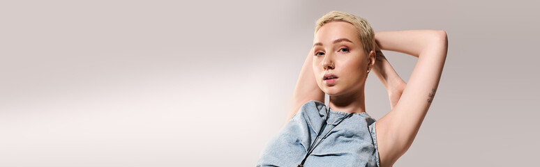 Stylish young woman poses confidently against a beige background, highlighting modern fashion