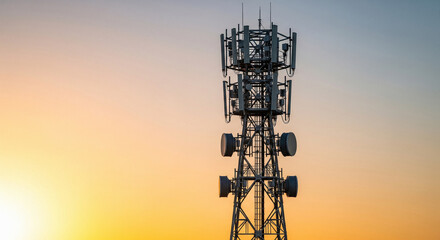 Silhouette of Cell Tower and Antenna Array Against a Gradient Sunset Sky