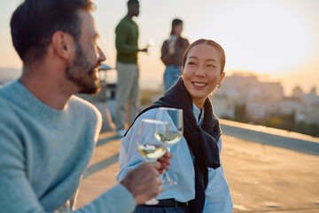 Diverse friends gathering on a rooftop, toasting with wine glasses while enjoying a social event and the city skyline view