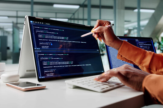 African American Woman Coding On Multiple Monitors