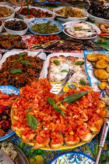 Delicious fresh cooked street food on daily food market in Palermo, Sicily, travel destination, food tourism Italy, variety of raw, roasted, grilled fish, seafood, meat, vegetables snacks or dshes