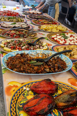 Delicious fresh cooked street food on daily food market in Palermo, Sicily, travel destination, food tourism Italy, variety of raw, roasted, grilled fish, seafood, meat, vegetables snacks or dshes